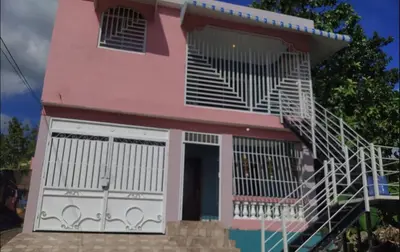 a pink house with a staircase in front of it at Don Carlos Recidencia