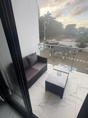 a couch sitting on a balcony with a table at LEVEL suites in Sosúa