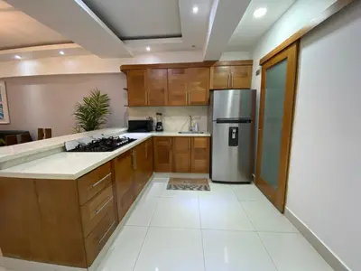 a kitchen with wooden cabinets and a stainless steel refrigerator at Maravilloso Descanso in Santo Domingo