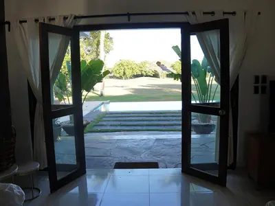 an open door with a view of a yard at Villa Bali in Paraíso