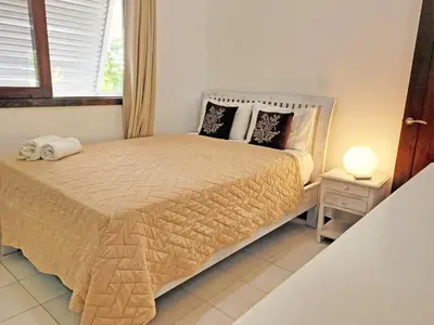 a bedroom with a bed and a lamp and a window at Villa Bali in Paraíso