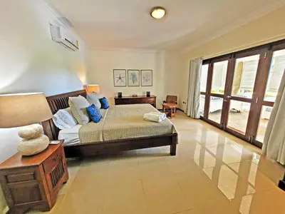 a bedroom with a bed and a large window at Villa Bali in Paraíso