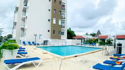a swimming pool with lounge chairs and a building at Apartamento en Boca Chica T2 707 in Boca Chica