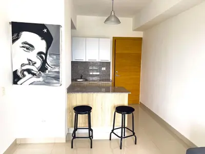 a kitchen with two bar stools and a painting of a woman at Apartamento en Boca Chica T2 707 in Boca Chica