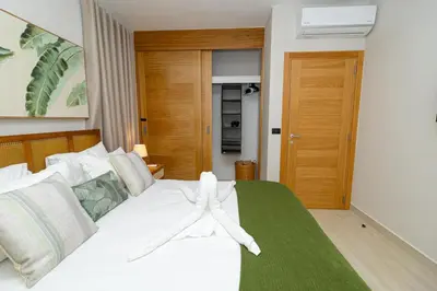 a white bed with a towel on top of it at Tropical 1BR Getaway in Dominicus Bayahibe - Garden Breeze