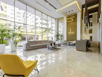 a lobby with a yellow chair and a couch at Comfy Apt, Rooftop Lounge, Pool in Santo Domingo