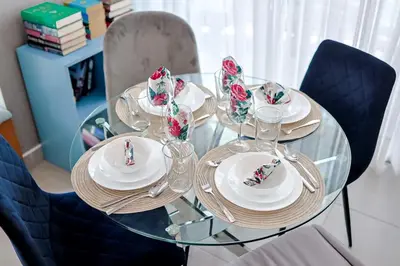 a glass table with plates and glasses on it at Comfy 1BR Apt, Centric Full AC in Santo Domingo