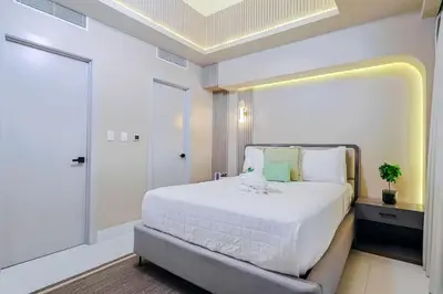 a bedroom with a large white bed and a large window at Luxury Upscale Centric Condo, in Santo Domingo