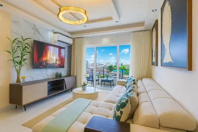 a living room with a large couch and a tv at Spacious, 3BD City Center Apt in Santo Domingo