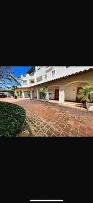 a large white building with a brick courtyard at Loft short walk to the beach and restaurant in La Fragata