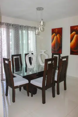 a dining room with a glass table and chairs at Charming Apartment in Jarabacoa with Shared Pool in Jarabacoa