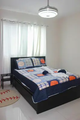 a bedroom with a bed with a quilt on it at Charming Apartment in Jarabacoa with Shared Pool in Jarabacoa