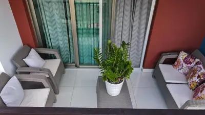 a balcony with two chairs and a potted plant at Charming Apartment in Jarabacoa with Shared Pool in Jarabacoa