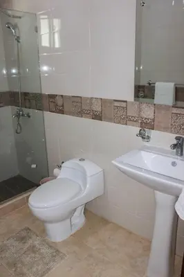a bathroom with a toilet and a sink at Charming Apartment in Jarabacoa with Shared Pool in Jarabacoa