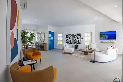 a large living room with yellow and white furniture at Sosua Ocean Village Villa 24 in Sosúa