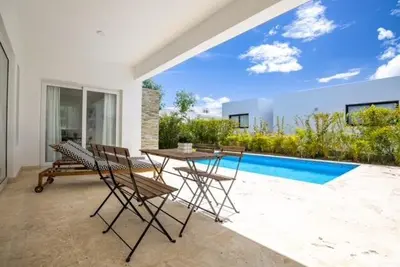 a patio with a table and chairs and a pool at Sosua Ocean Village Villa 24 in Sosúa