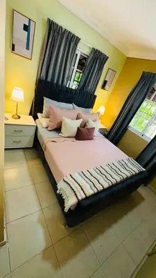 a bedroom with a large bed with a black headboard at green oasis vacation retreat in La Grúa