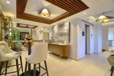 a kitchen with a bar with white stools at Acqualina’s View @ Santo Domingo in Santo Domingo