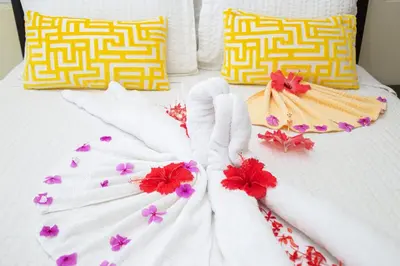 a bed with white gloves and flowers on it at 2 bedrooms Villa 16 at Villas Tisu in Sosúa