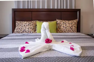 a bed with white towels and pink flowers on it at 2 bedrooms Villa 16 at Villas Tisu in Sosúa