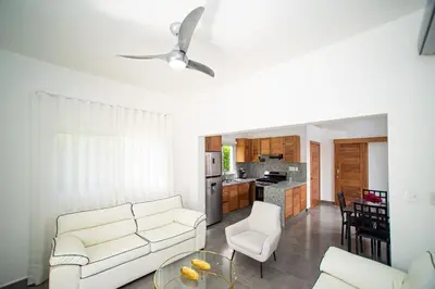 a living room with a white couch and a kitchen at 2 bedrooms Villa 16 at Villas Tisu in Sosúa