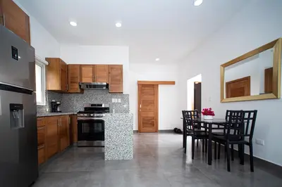 a kitchen with wooden cabinets and a table with chairs at 2 bedrooms Villa 16 at Villas Tisu in Sosúa