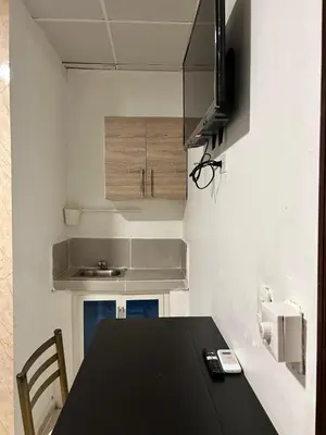 a kitchen with a black table and a microwave at Dominico Colonial in Santo Domingo