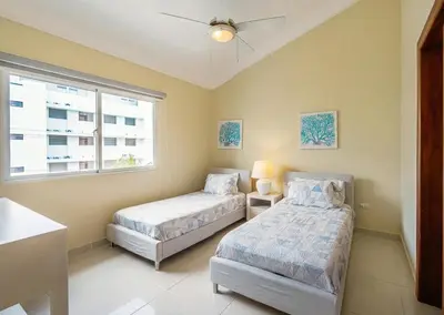 a bedroom with two beds and a window at Stylish Punta Cana Apartment - Eden Caribe in Punta Cana