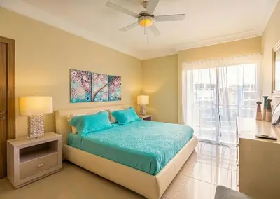 a bedroom with a bed and a ceiling fan at Stylish Punta Cana Apartment - Eden Caribe in Punta Cana