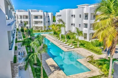 an overhead view of a swimming pool with palm trees and buildings at Swim-Up Paradise, AirBB for more info in Punta Cana