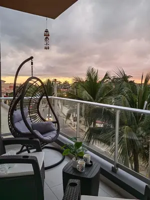 a balcony with a chair and a view of a city at Apt in luxurious condominium near the beach in Juan Dolio