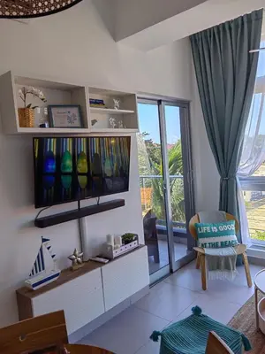 a living room with a tv and a window at Apt in luxurious condominium near the beach in Juan Dolio