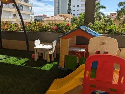 a childs play area with a toy house and a playground at Apt in luxurious condominium near the beach in Juan Dolio