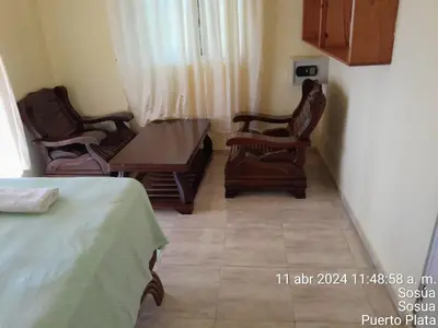 a dining room with two chairs and a table and a table and chairs at 4 bedroom villa, private pool, ocean view, security in Sosúa