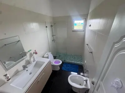a white bathroom with a sink and a toilet at Modern 3-Bedroom Apartment with Pool in Boca Chica