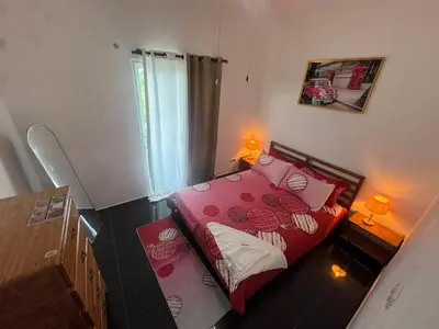 a bedroom with a red bed with pink pillows at Modern 3-Bedroom Apartment with Pool in Boca Chica