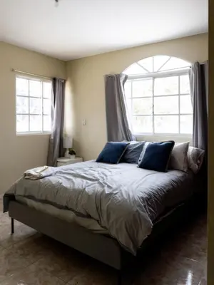 a bedroom with a bed with blue pillows and a window at 3BR Villa Newly Renovated-5 min to Playa Dorada H1 in Puerto Plata