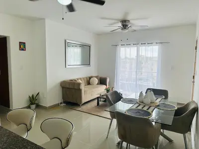 a living room with a dining table and a couch at Apartamento muy cerca de la embajada Americana in Santo Domingo