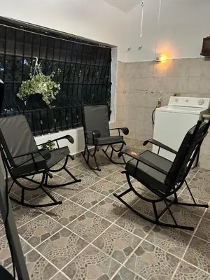 a room with three rocking chairs and a fireplace at Entire House in Santo Domingo Este in Los Frailes