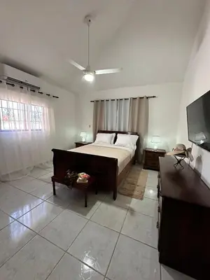 a bedroom with a bed and a flat screen tv at Entire House in Santo Domingo Este in Los Frailes