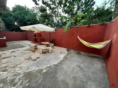 a patio with an umbrella and a bench and a hammock at Entire House in Santo Domingo Este in Los Frailes