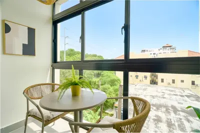 a table and chairs in a room with a large window at ®{Designer~City~Stay} @DowntownSD NearPark1BR in Santo Domingo