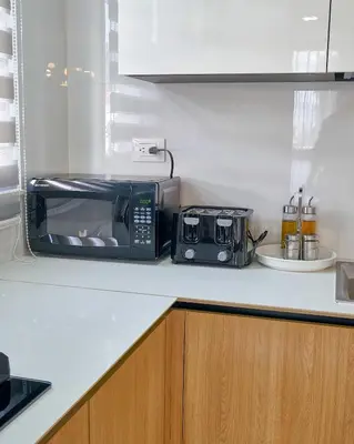 a black microwave sitting on a counter in a kitchen at ®2BR{The~City~Center}@DTown PoolGym NearCecilip in Santo Domingo