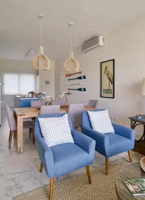 a living room with blue chairs and a table at {3BR~Beach~Condo}@LakeView PlayaBonita PoolLUX in Las Terrenas
