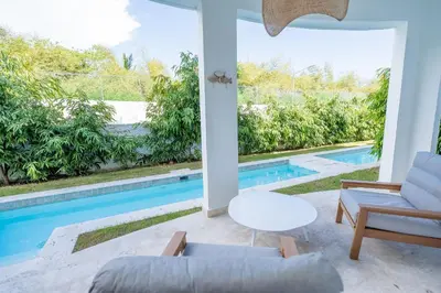a living room with a view of a swimming pool at Suite Boho Swim-Up | Acceso Directo. Playa Privada in Punta Cana