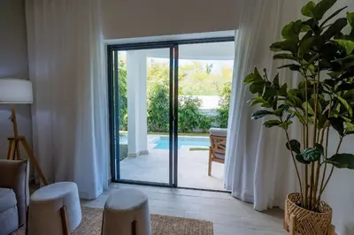 a living room with a sliding glass door at Suite Boho Swim-Up | Acceso Directo. Playa Privada in Punta Cana