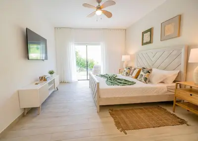 a bedroom with a bed and a ceiling fan at Suite Boho Swim-Up | Acceso Directo. Playa Privada in Punta Cana