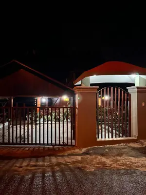 a gate in front of a house at night at Wooden Paradise in Jarabacoa in Jarabacoa