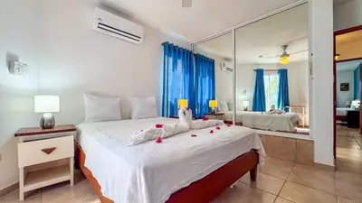 a bedroom with a large white bed with a mirror at Renaissance Residence Cabarete in Cabarete