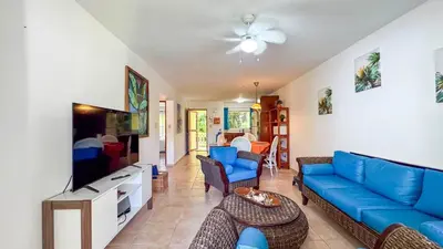 a living room with a blue couch and a tv at Renaissance Residence Cabarete in Cabarete
